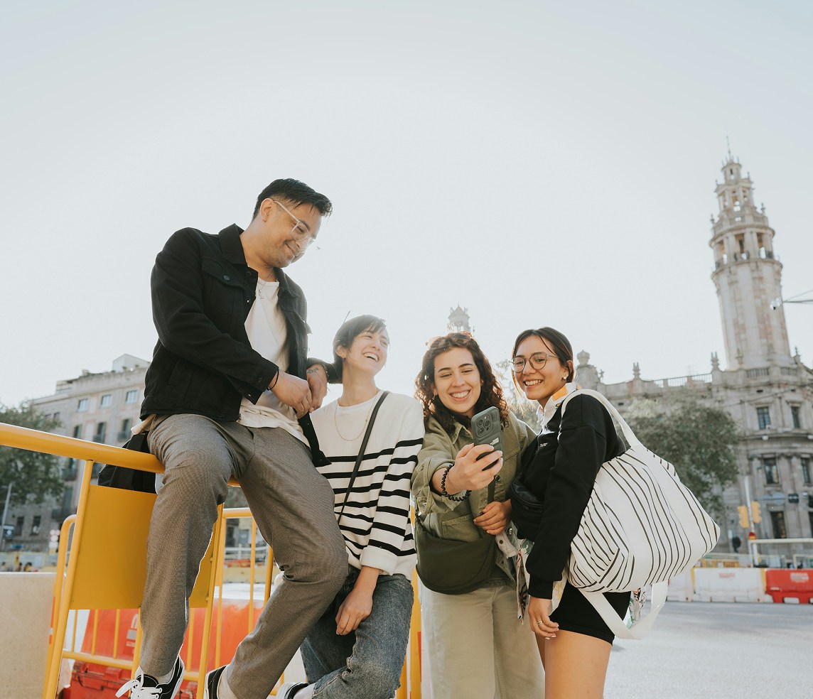 A group of four friends smiling and posing for a photo